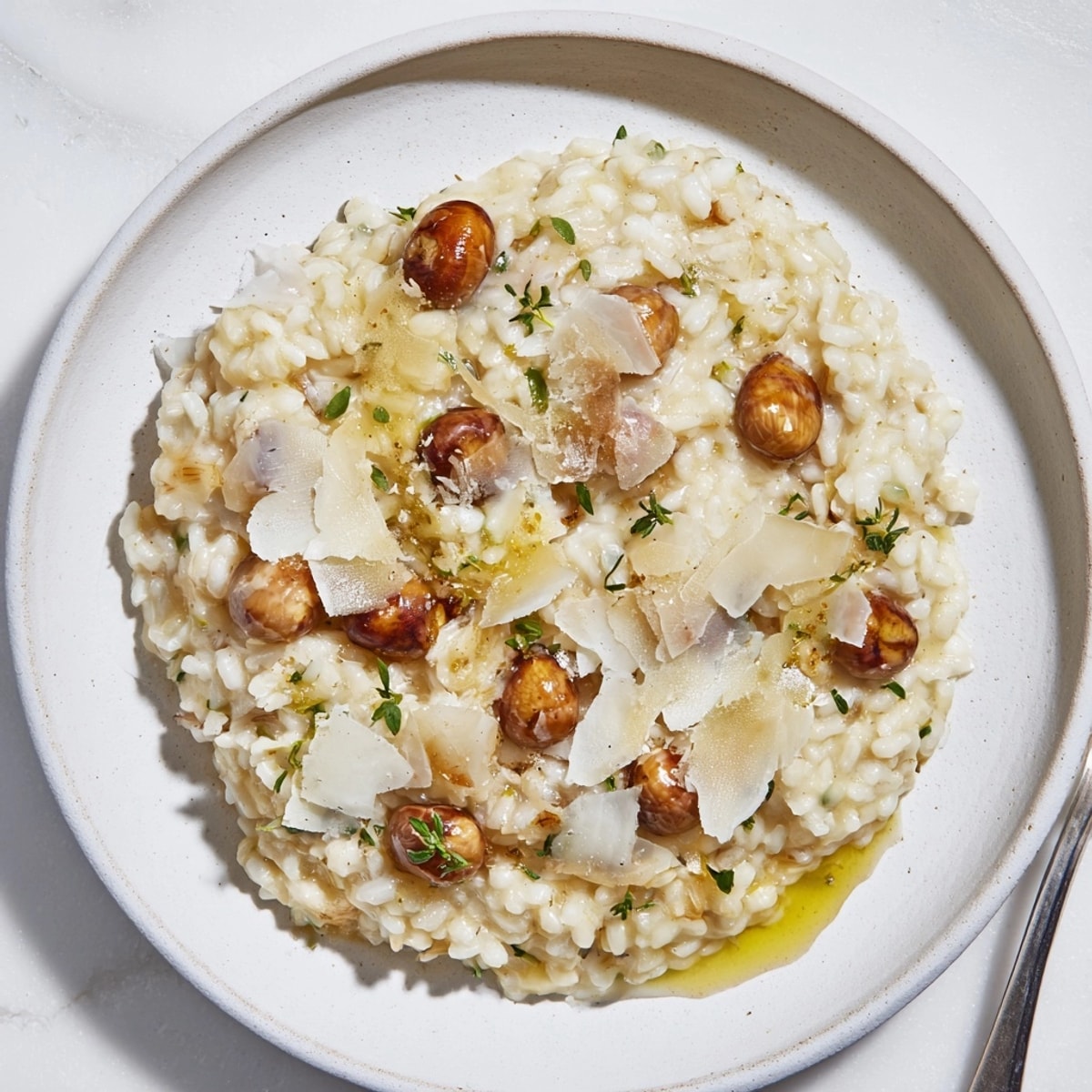 Gros plan sur un risotto aux châtaignes onctueux et fumant, cuit à la perfection, saupoudré de parmesan.