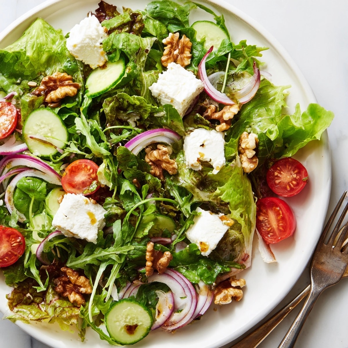 Image d'une salade savoureuse de chèvre et noix, avec des légumes verts frais et une vinaigrette acidulée.