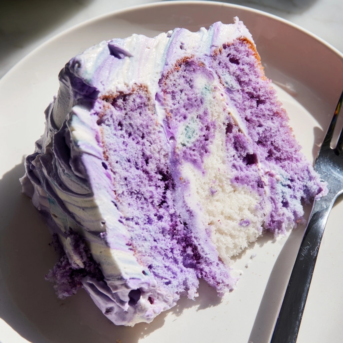 Gâteau moelleux à l'ube : aperçu d'une tranche violet profond prête à être savourée.