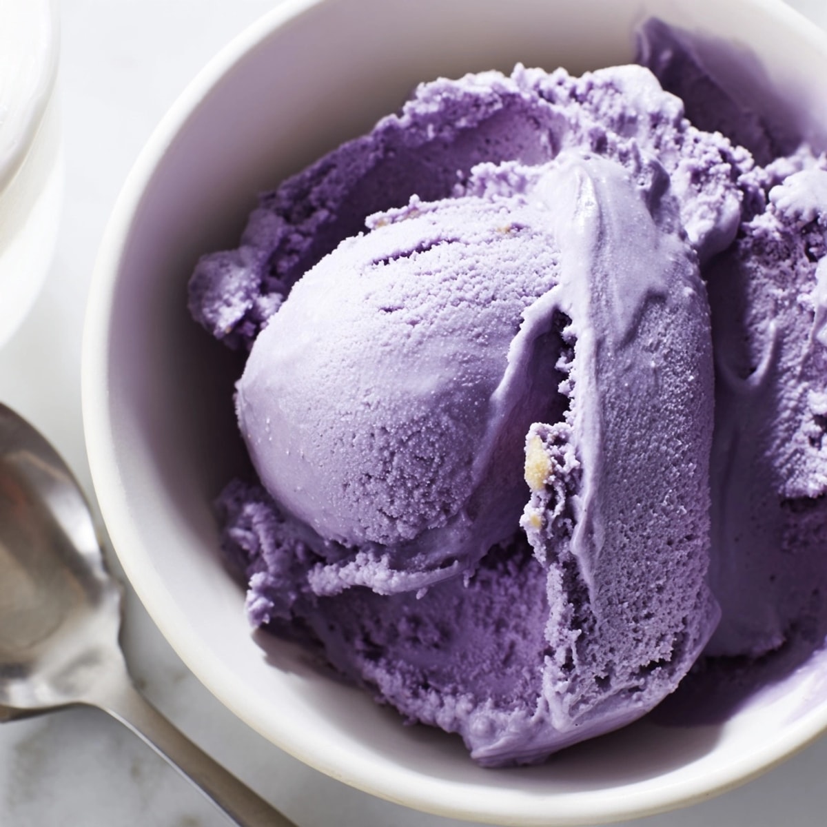 Une portion parfaite de crème glacée crémeuse à l'ube, prête à savourer directement sortie du congélateur.