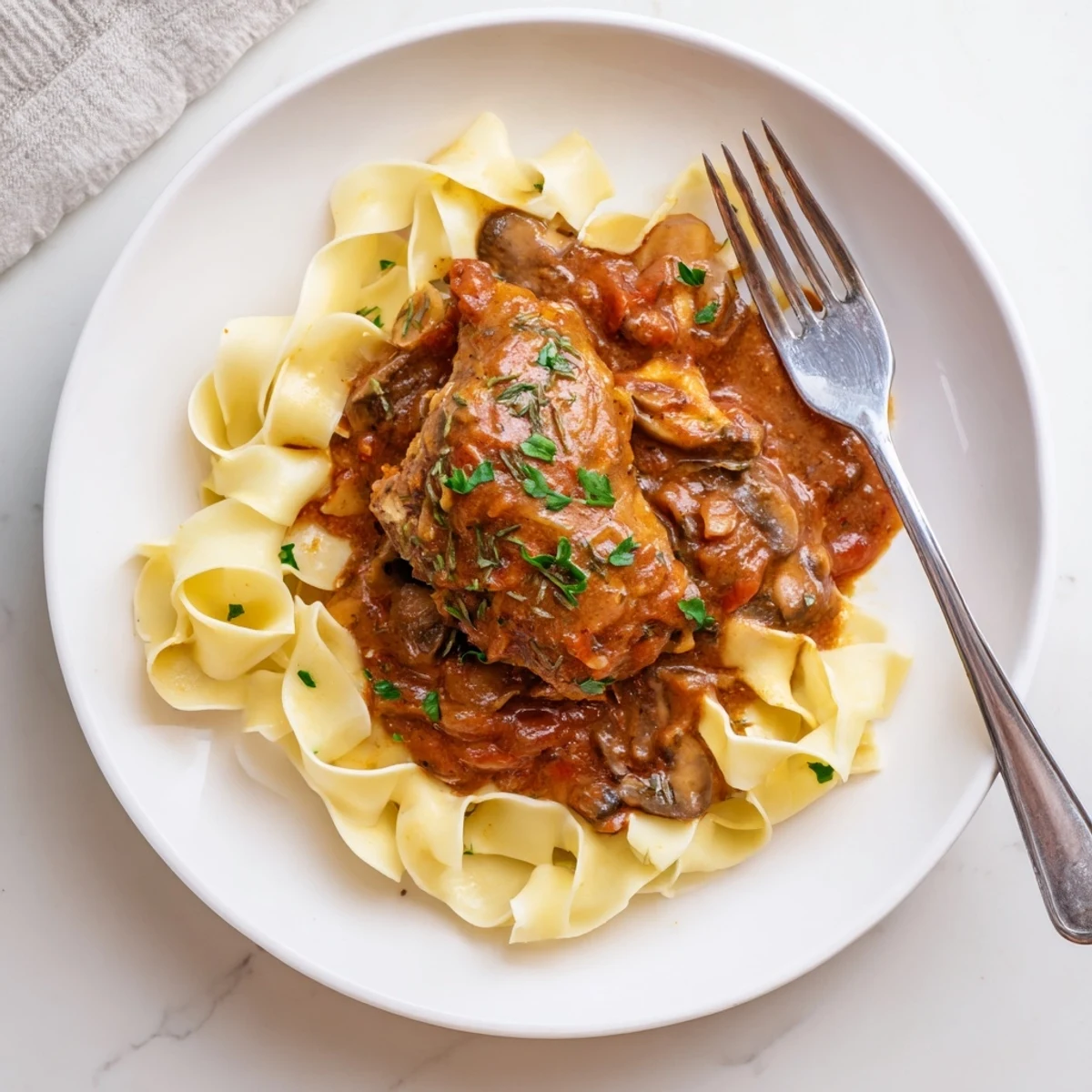 Nouilles au beurre généreusement enrobées, accompagnant un savoureux Poulet Chasseur d'inspiration française.