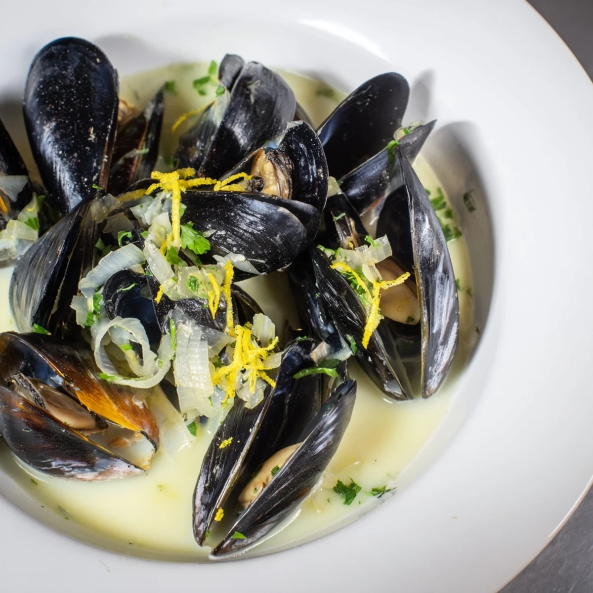 Beautiful, steaming bowl of 30-minute classic creamy mussels with a rich, flavorful broth.