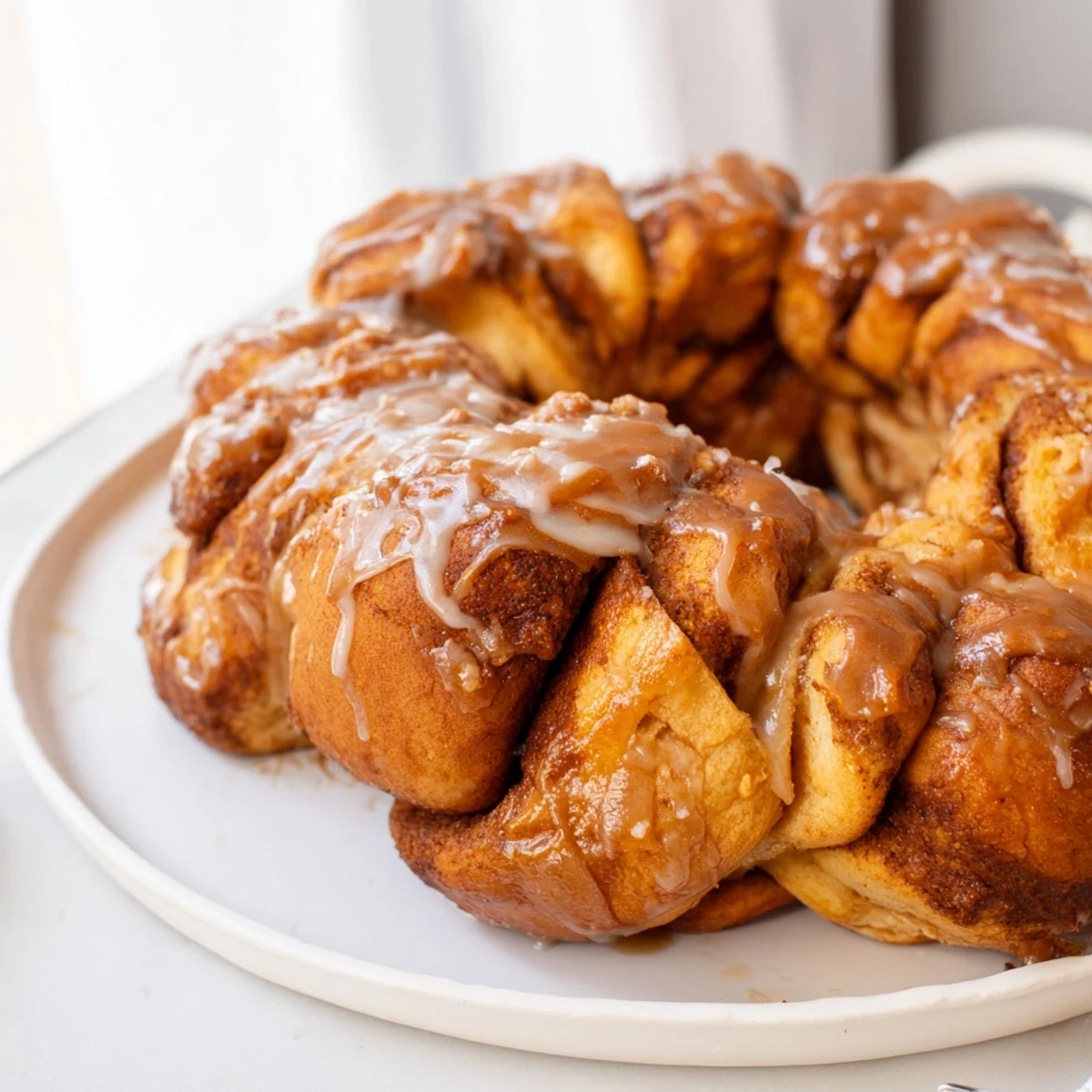 A warm cinnamon roll pull-apart wreath, covered in sweet, vanilla glaze for brunch.