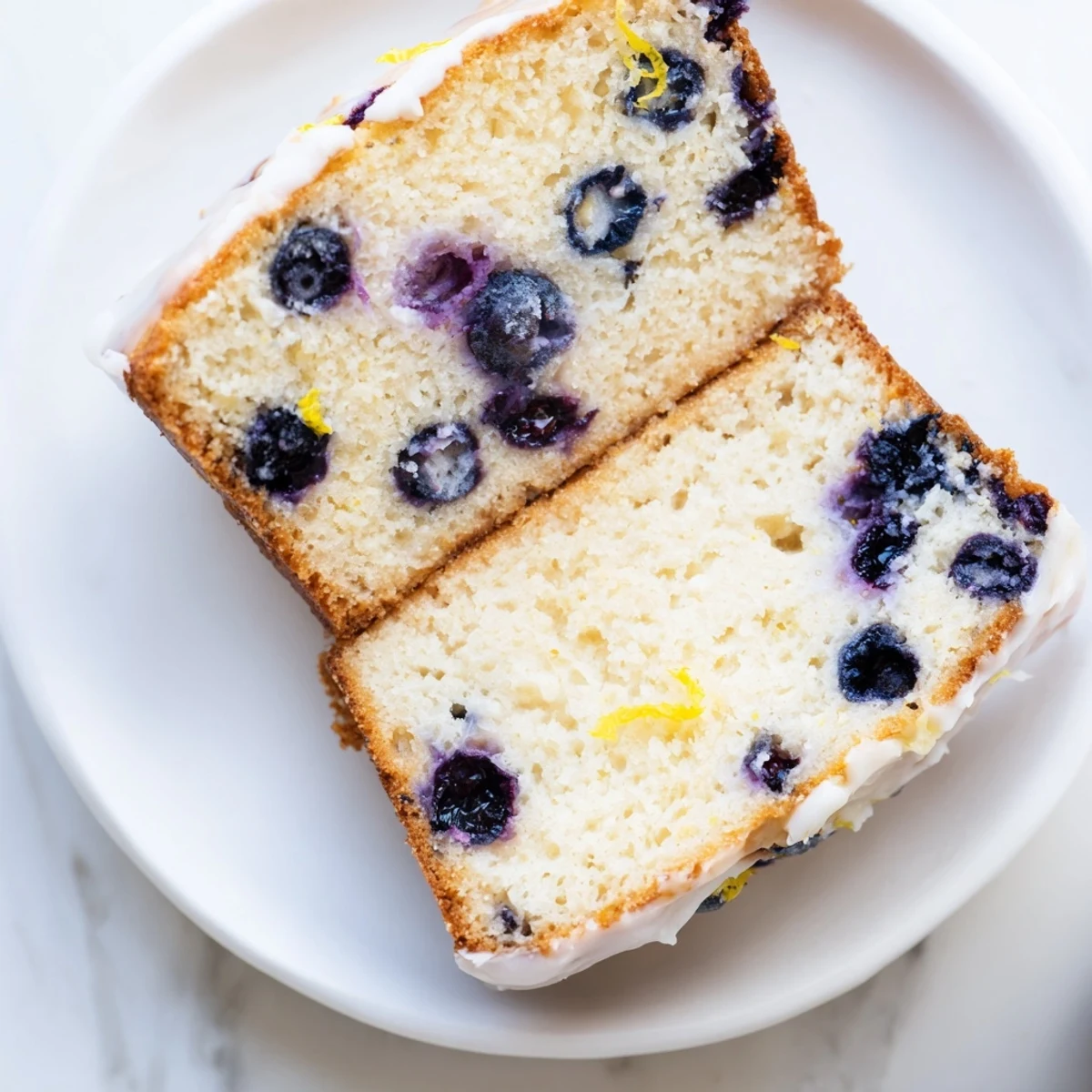 Fresh blueberries dot a golden Lemon Blueberry Yogurt Loaf, perfect with a cup of tea.