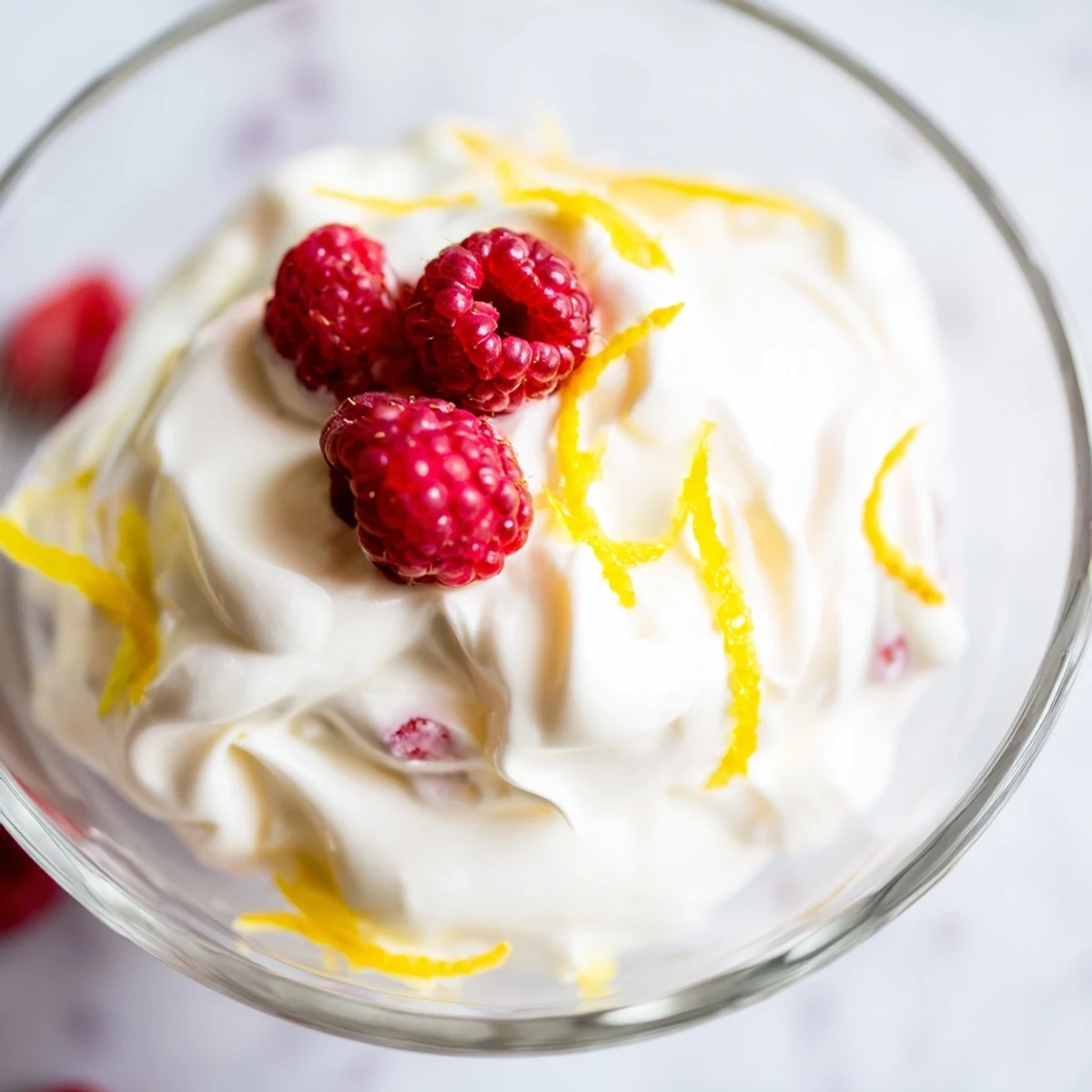 Un Lemon Fool British garni de crème au citron, fraises et biscuit sablé pour un dessert rafraîchissant.