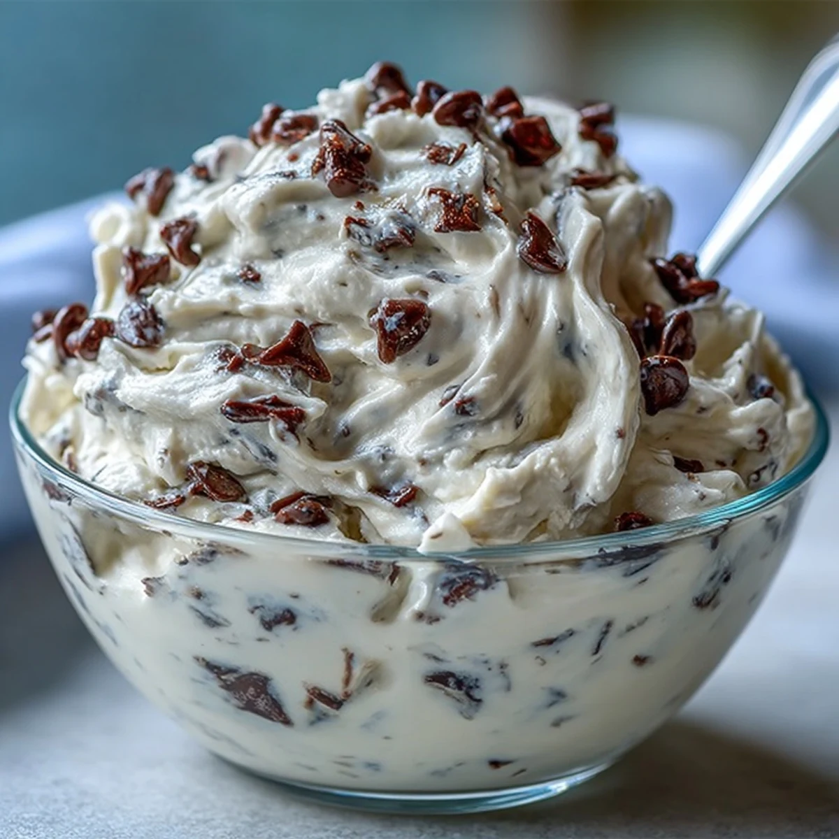 Cette version de Greek Yogurt Cookie Dough, riche en protéines, apparaît dense et onctueuse sur une cuillère en bois.