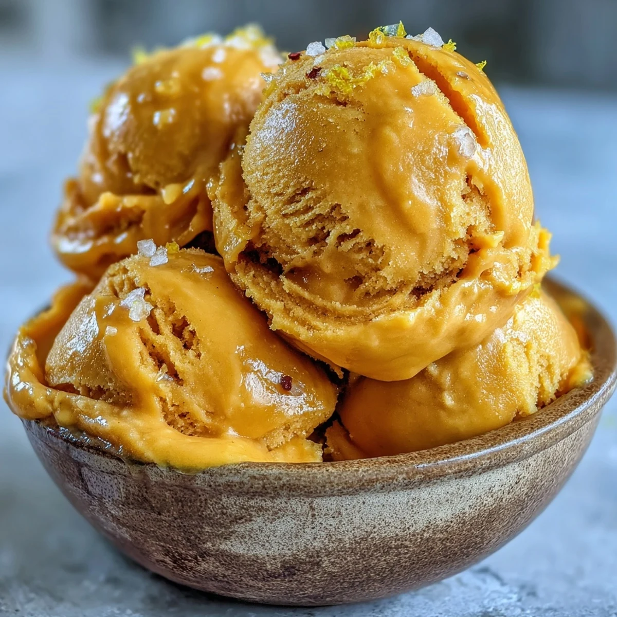 Homemade mango sorbet in a waffle cone on a rustic table