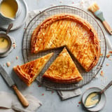 Une tarte au citron est servie sur un plateau avec une fourchette et une cuillère.