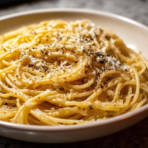 Une assiette de spaghetti avec des herbes et des noix de cajou.