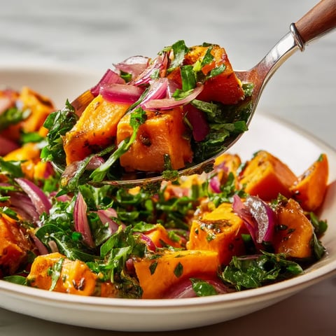 Une assiette de salade contenant des légumes verts et des légumes rouges.
