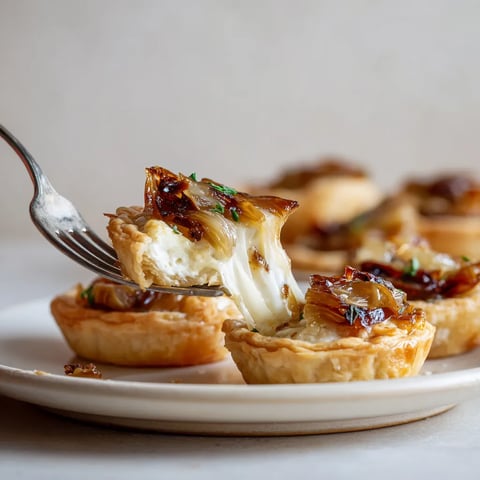 Une assiette de tartelettes aux endives caramélisées et au chèvre.