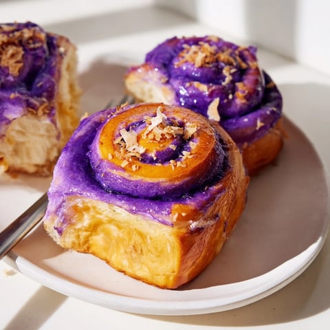 Close-up of vibrantly purple Ube Brioche Rolls fresh from the oven, ready to eat.