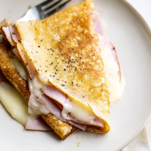 Les crêpes salées au jambon et fromage, garnies de fromage fondant, idéales pour le petit-déjeuner.  
