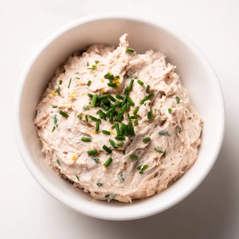 Pâté de thon crémeux servi sur des tranches de baguette croustillante.