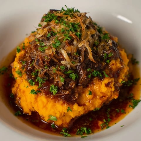 Savory Oxtail Parmentier with spiced sweet potato mash, ready for delicious serving.