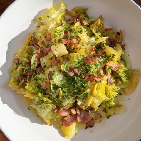Golden potatoes and crispy bacon highlight Sautéed Savoy Cabbage; a hearty, flavorful main course.