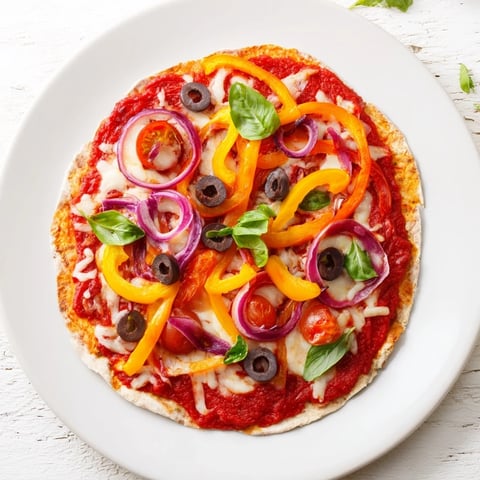 Homemade Tortilla Pizza topped with melted mozzarella and fresh basil, ready to eat.