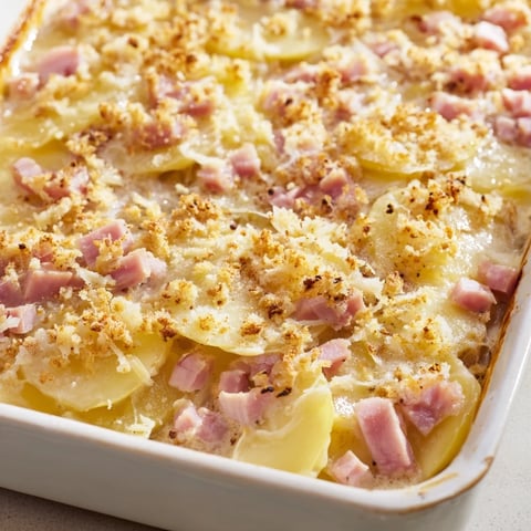 Golden brown Parisian Ham & Cheese Gratin bubbling with melted Gruyère, perfect for a cozy dinner.