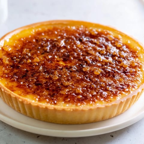 Golden-brown Express Crème Brûlée Frosting Tartlets with caramelized sugar crust on a white plate.