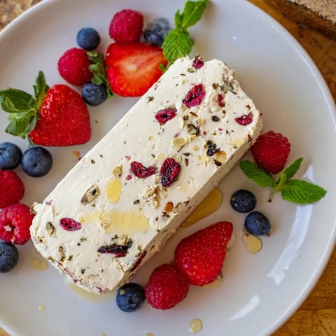 A vibrant image showcases a cranberry & goat cheese log with fresh berry garnish, a delightful appetizer.