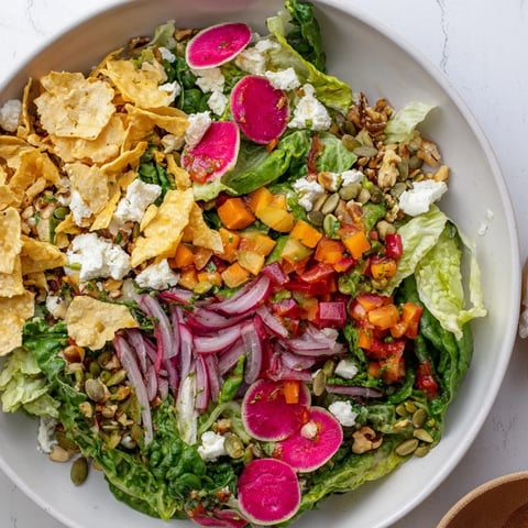A vibrant winter salad with snowflake tortilla chips, salsa, and fresh ingredients, ready to enjoy.
