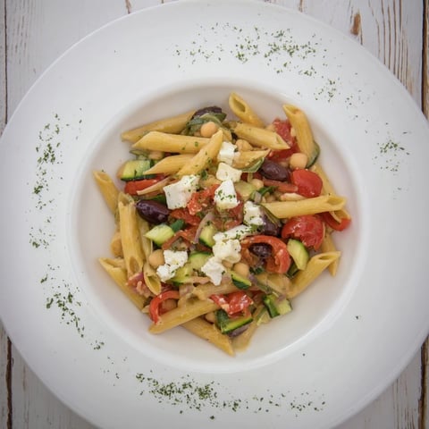 Mediterranean pasta salad with chickpeas, bursting with colorful veggies and creamy feta, ready to serve.