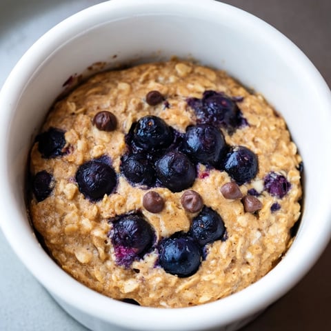 A steaming ramekin of blueberry baked oats ready to be enjoyed as a tasty breakfast.