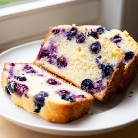 A sliced Lemon Blueberry Yogurt Loaf showcasing a tender crumb, ideal breakfast treat.