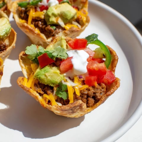 Mini Taco Cups filled with seasoned beef and melted cheese, perfect for a flavorful appetizer.