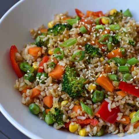 A vibrant bowl of vegetable fried rice, showing colorful veggies and fluffy rice.