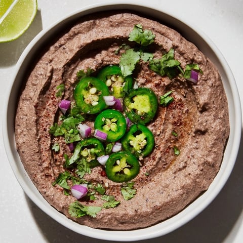 Spicy Black Bean Dip, a vibrant appetizer, is ready with tortilla chips for dipping.