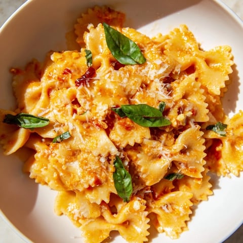 Creamy Tomato Basil Bowtie Pasta: a bowl of pasta with fresh basil and Parmesan cheese.