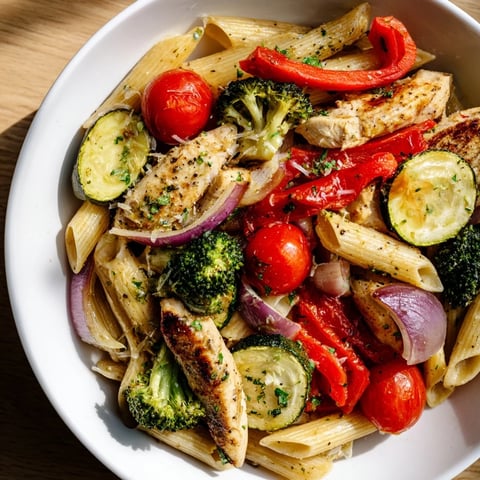 Garlic Herb Chicken & Veg Pasta: A close-up of steaming pasta with roasted chicken, fresh herbs, and colorful vegetables.