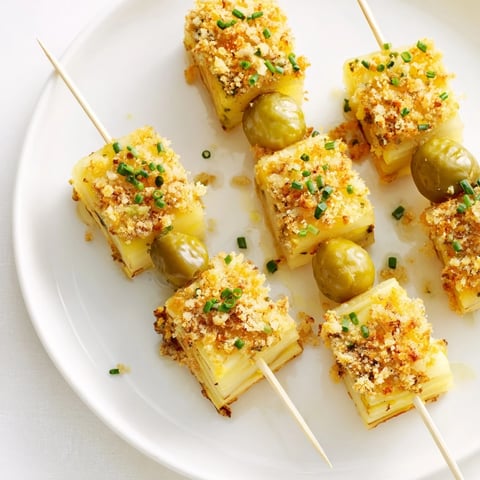 Des brochettes de gratin dauphinois avec cornichons, cuites à la perfection dorée.  