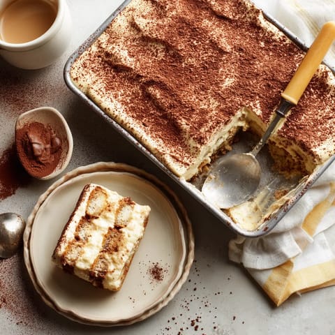 Une tasse de café est placée sur une table avec une baguette de dessert et une fourchette.