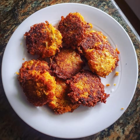 Une plaque de porcelaine contenant des patties de viande frites.