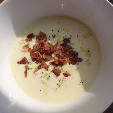 Délicieuse soupe au parmesan, garnie de bacon croustillant, pour un moment réconfortant.  