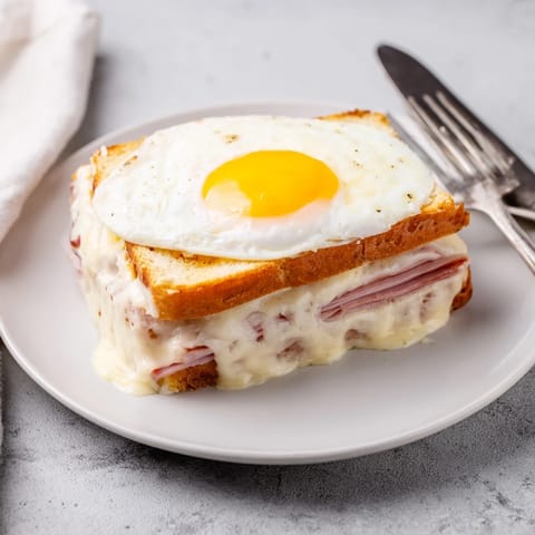 Dégustez un sandwich Croque Madame croustillant, savoureux, et plein de fromage fondant.  