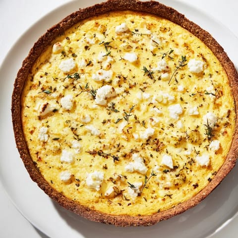 A slice of fluffy potato crust leek and goat cheese quiche garnished with fresh thyme.