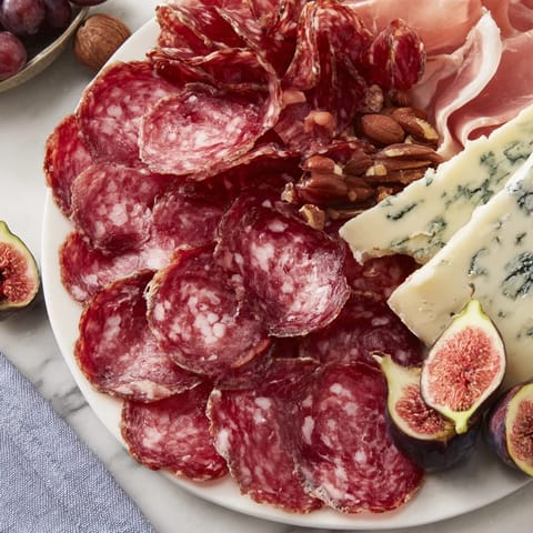 A beautiful Majestic Venison Charcuterie Platter, overflowing with savory meats, fresh fruits, and nuts.