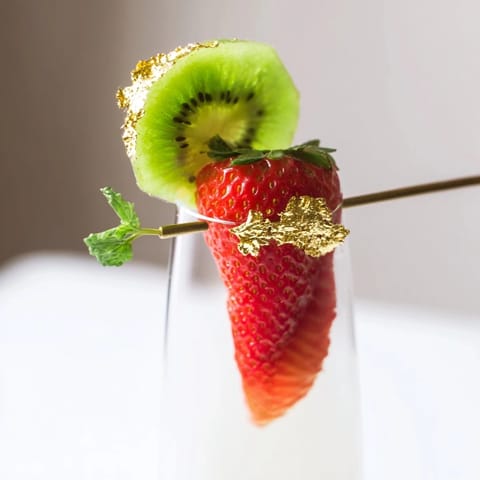 Close-up of elegant champagne flute fruit garnishes, ready to enhance any celebratory toast.