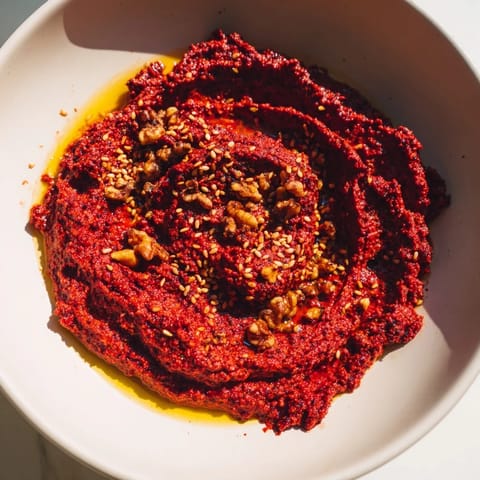Close-up of creamy Syrian Muhammara, showcasing the roasted red peppers and walnuts.