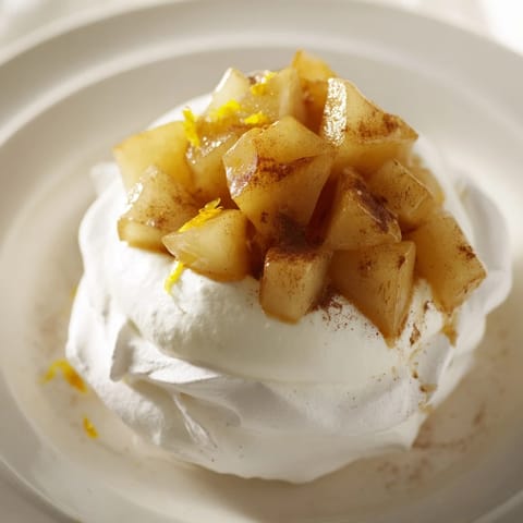 Mini Hot Toddy Pavlovas croustillants remplis de poires fondantes et de crème légère sur fond de cannelle.
