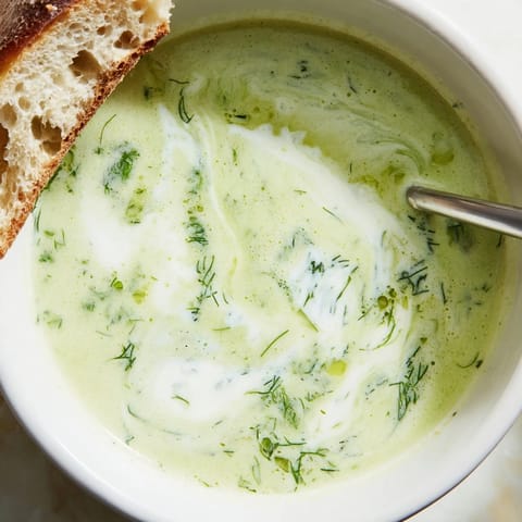 Une texture soyeuse et lisse de la soupe veloutée à la céleri et aux herbes, avec de la crème fraîche fouettée et des herbes fraîches ciselées.