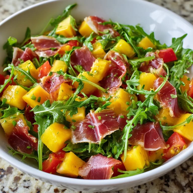 Une assiette de salade contenant des légumes et des fruits, tels que des tomates, des mangos et des poivrons.