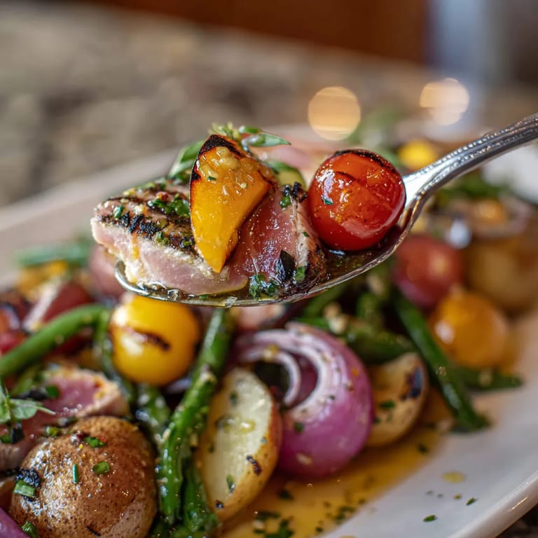 Une assiette de plats cuits, y compris des légumes et des viandes, est servie avec une fourchette.