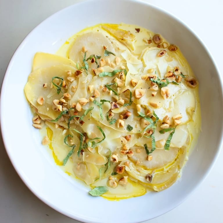 Creamy Sunchoke Gratin with fresh tarragon and toasted hazelnuts, perfect for an elegant dinner.