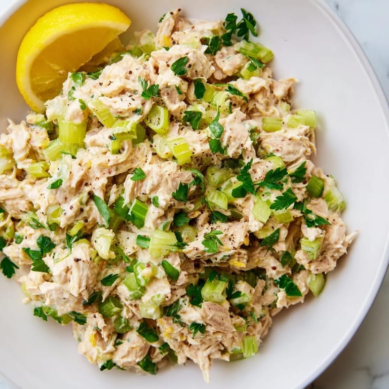A bowl of fresh Spicy Zesty Tuna Salad featuring flaky tuna and herbs, ideal for sandwiches or wraps.
