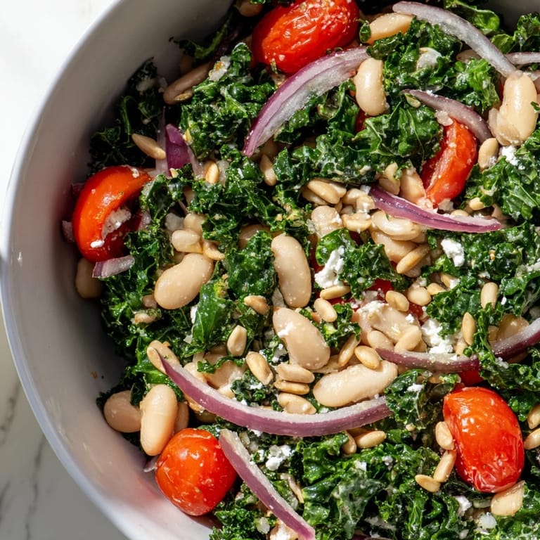 Une assiette généreuse de White Bean and Kale Salad, garnie de tomates cerises et de graines de tournesol grillées.