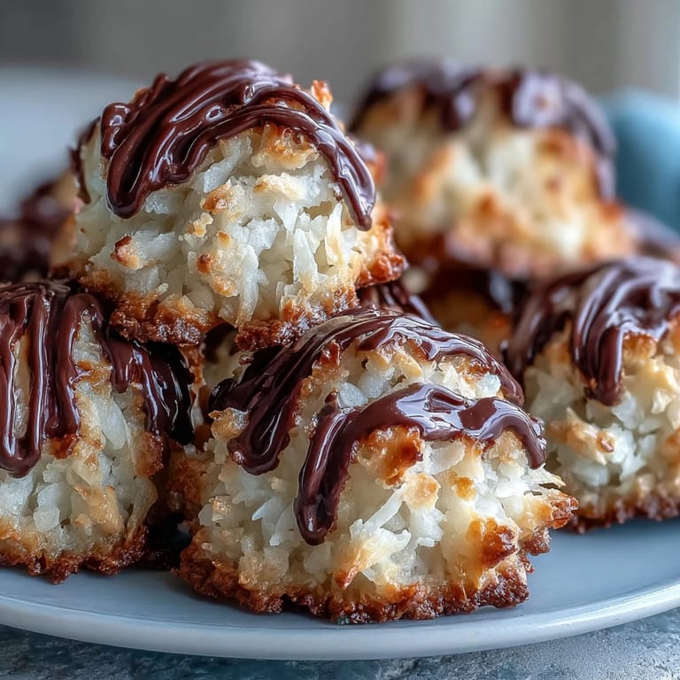 Freshly baked Vegan Coconut Macaroons with Dark Chocolate Drizzle paired with coffee on a cozy table.